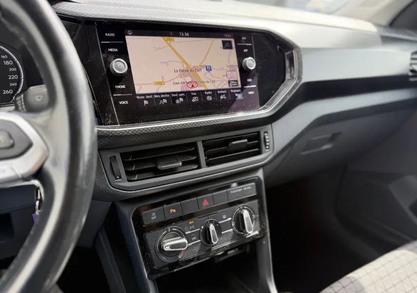 Vue intérieure du tableau de bord du Volkswagen T-Cross 1.6 TDI 95 Lounge Business 2019, avec écran tactile et commandes climatisation.