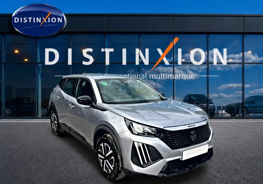 Peugeot 2008 gris en 3/4 avant droit, avec calandre noire distinctive et feux LED verticaux marquants.