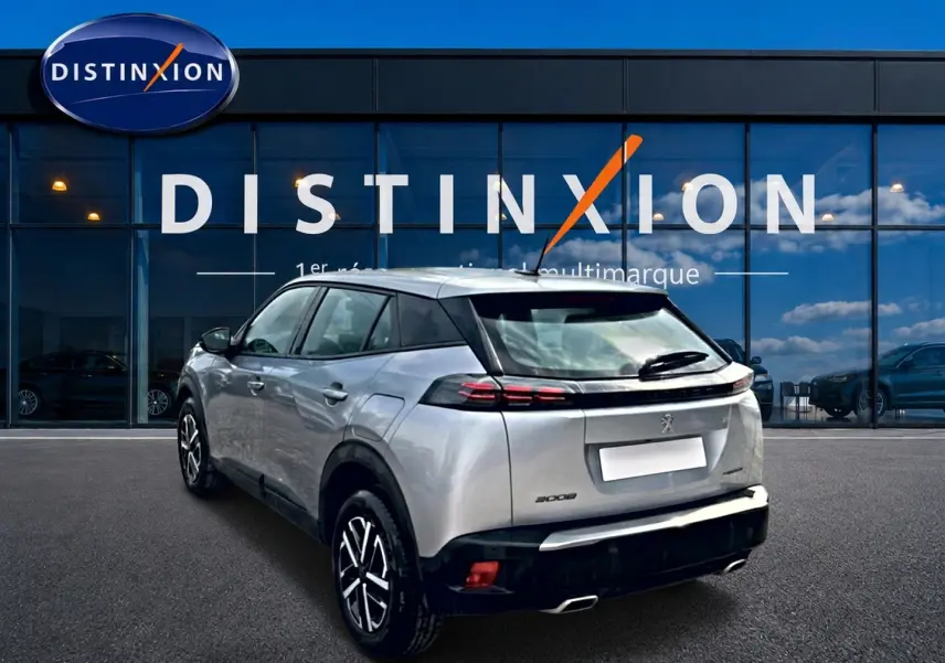Vue 3/4 arrière droite d’un Peugeot 2008 gris 2025 avec feux arrière à LED et becquet noir.