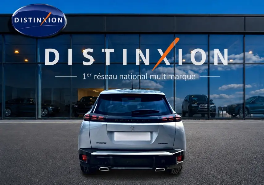 Vue arrière d'un Peugeot 2008 gris 2025 avec feux LED et double sortie d'échappement, devant une vitrine Distinxion.