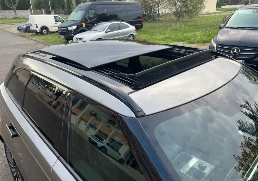 Vue en plongée du toit ouvrant ouvert d'un Range Rover Velar gris 2019, mettant en valeur sa finition noire brillante.
