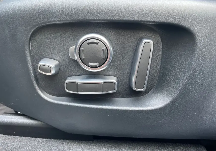 Gros plan sur les commandes de réglage électrique du siège côté conducteur du Range Rover Velar gris 2019.