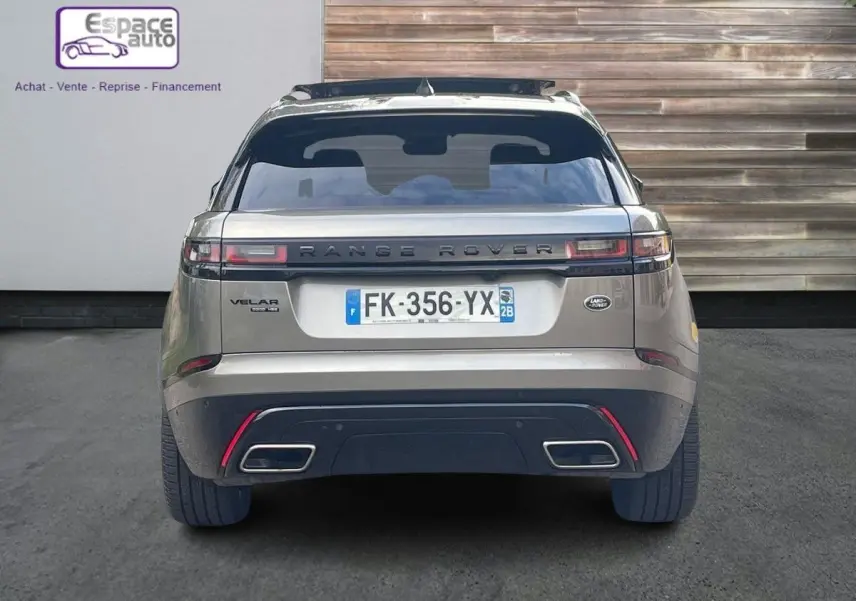 Vue arrière d'un Range Rover Velar gris 2019 avec plaques françaises, feux horizontaux et double sortie d'échappement rectangulaire.