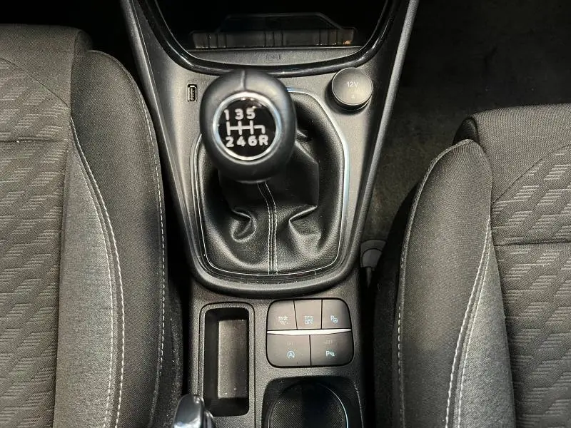 Vue plongeante sur la boîte manuelle noire et les sièges en tissu gris du Ford Puma 2022 Titanium Business