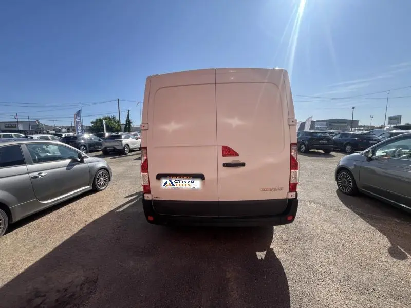 Vue arrière d'un Renault Master blanc Glacier garé en extérieur, avec portes arrière fermées et plaque d'immatriculation visible.