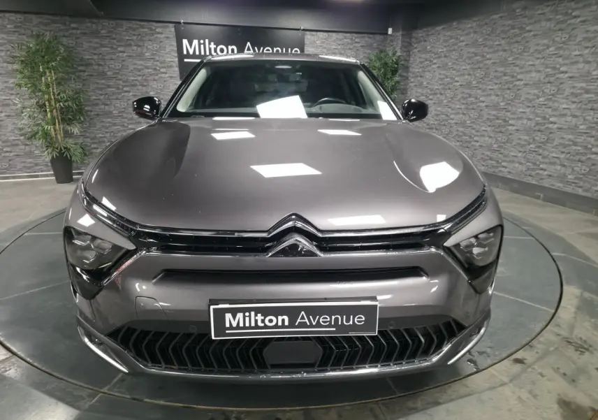 Vue frontale d'une Citroën C5 X hybride rechargeable gris métallisé avec calandre noire et logo chromé visible.