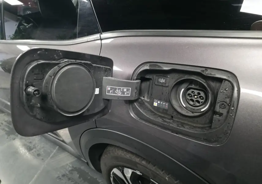 Trappe de recharge ouverte côté gauche sur Citroën C5 X hybride rechargeable gris métallisé avec jante alliage 19 pouces AeroX.