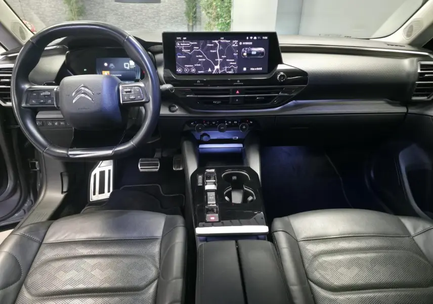Intérieur noir cuir du Citroën C5 X Hybrid 2023, vue avant sur tableau de bord et console centrale moderne.