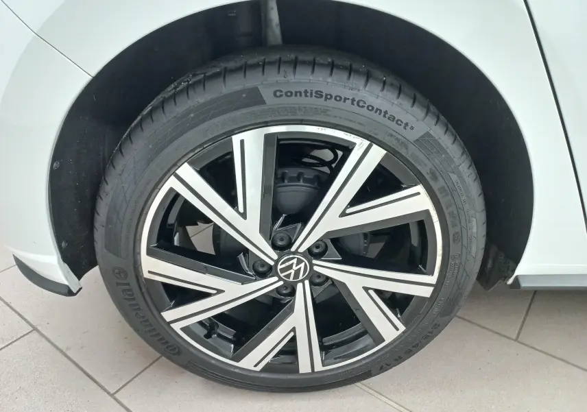 Gros plan sur la roue avant droite d'une Volkswagen Polo blanc pur avec jante alliage R-Line bicolore.