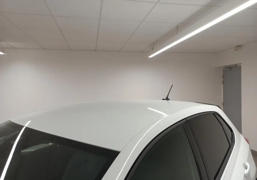 Vue partielle du toit et des vitres arrière surteintées d'une Volkswagen Polo Blanc Pur, version 2025 en intérieur.