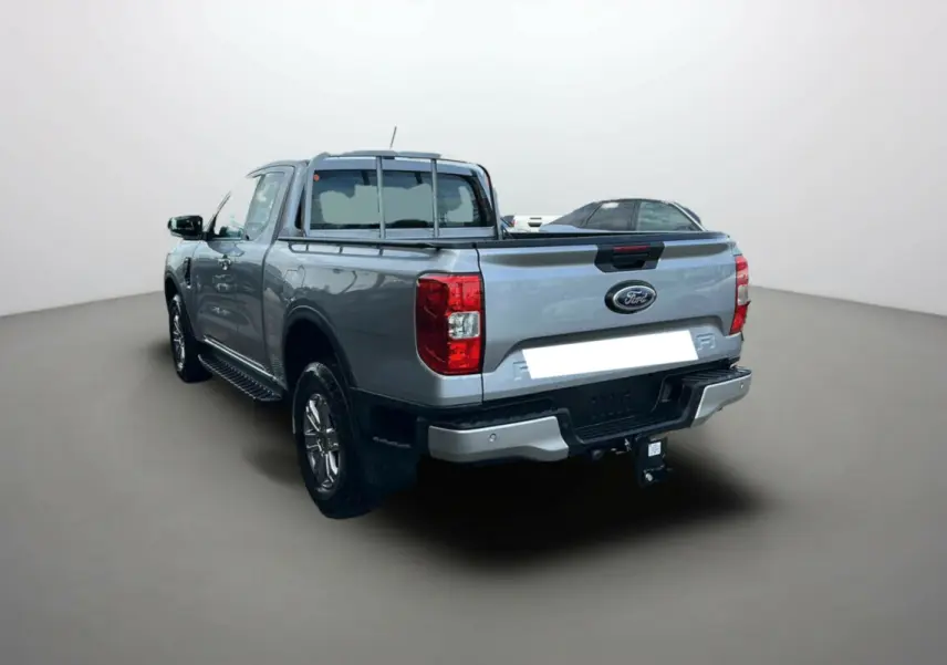 Vue 3/4 arrière droite du Ford Ranger gris iconic avec attelage et marchepieds latéraux visibles.