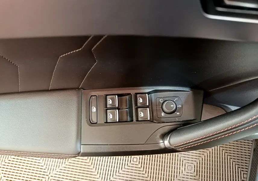 Détail des commandes de lève-vitres et réglage des rétroviseurs sur la porte côté conducteur d’une CUPRA Formentor gris foncé.