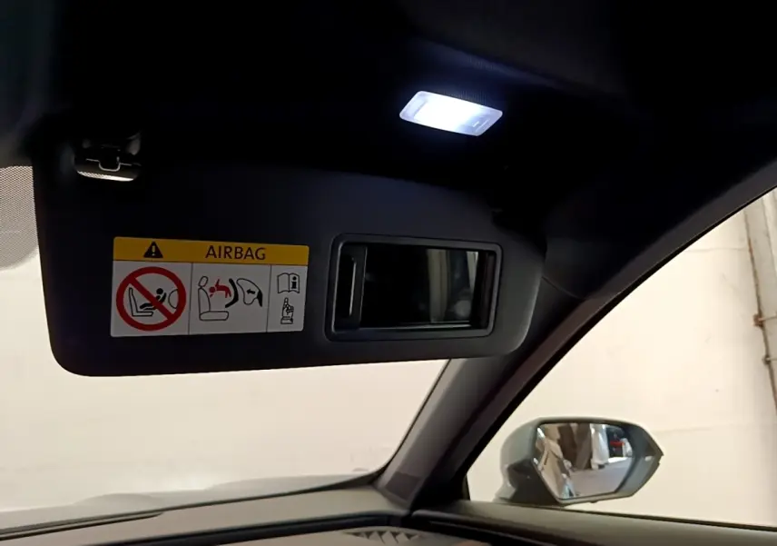 Détail intérieur du pare-soleil côté conducteur avec miroir et lumière allumée dans une CUPRA Formentor gris foncé.