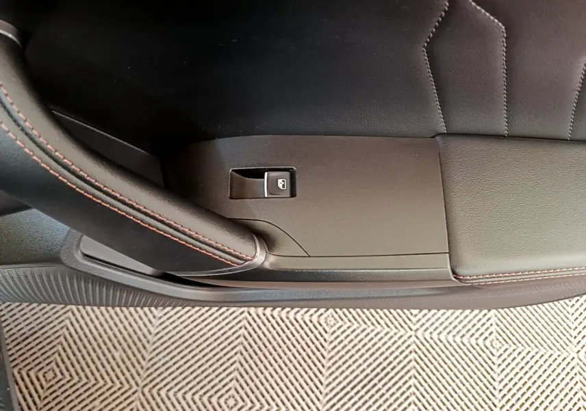 Détail de la porte intérieure côté gauche de la CUPRA Formentor gris foncé avec bouton de verrouillage et surpiqûres rouges.