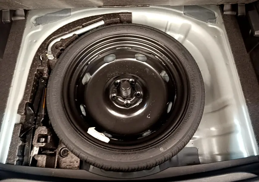 Vue plongeante sur la roue de secours galette noire dans le coffre gris clair du CUPRA Formentor 2022.