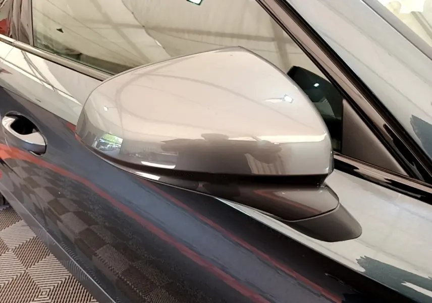 Gros plan sur le rétroviseur côté gauche gris foncé du CUPRA Formentor 2022, avec poignée de porte visible.