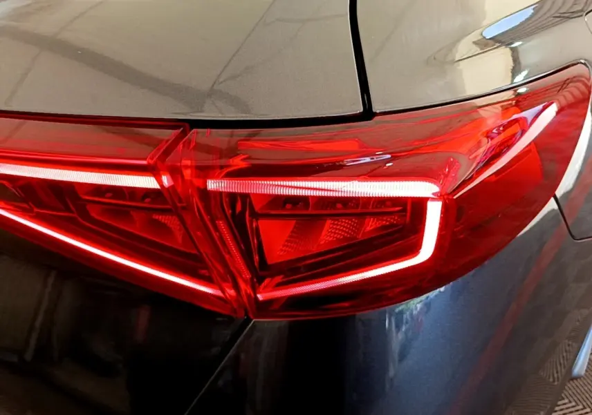 Gros plan sur le feu arrière droit rouge vif du CUPRA Formentor gris foncé, soulignant ses lignes anguleuses modernes.