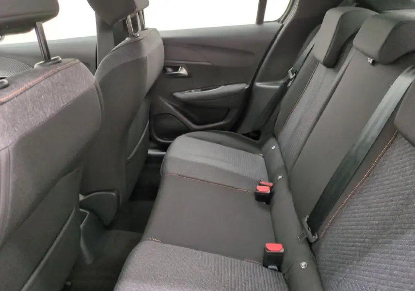 Vue intérieure côté droit sur la banquette arrière gris foncé avec surpiqûres orange de la Peugeot 208 2025 Style Navigation.