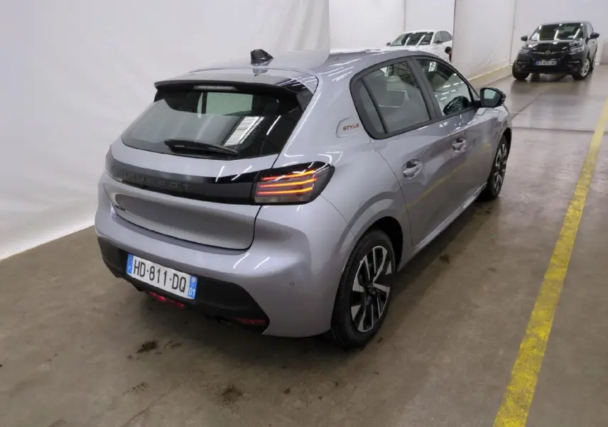 Peugeot 208 gris clair vue 3/4 arrière droit avec feux arrière LED et badge Style sur custode.
