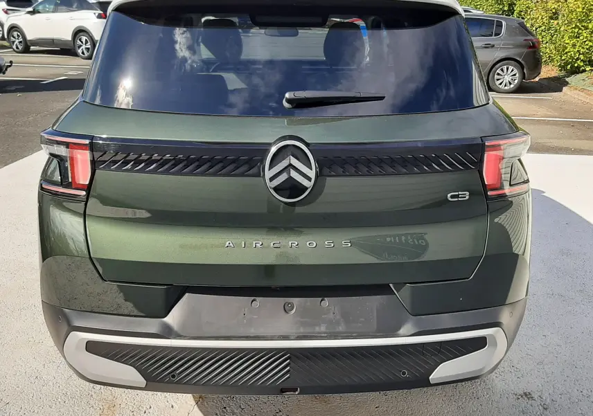 Vue arrière d'un Citroën C3 Aircross 2025 vert Montana avec toit blanc, mettant en valeur son logo et ses feux distinctifs.