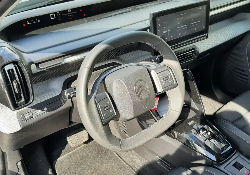 Vue intérieure côté conducteur du Citroën C3 Aircross 2025, tableau de bord noir avec écran tactile et volant compact.