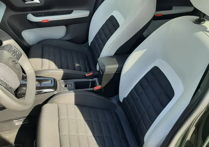 Vue intérieure côté conducteur du Citroën C3 Aircross 2025, sièges bi-ton noir et blanc avec surpiqûres apparentes.