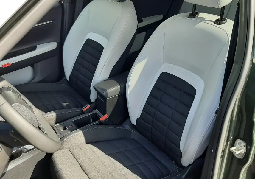 Vue intérieure côté conducteur de la Citroën C3 Aircross 2025, sièges bicolores noir et blanc avec coutures apparentes.