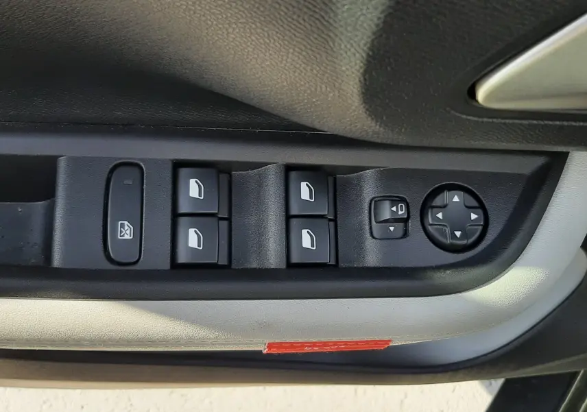 Vue rapprochée des commandes de lève-vitres et réglage des rétroviseurs côté conducteur d'une Citroën C3 Aircross 2025.