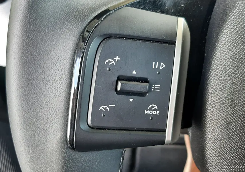 Gros plan sur les commandes de régulateur de vitesse au volant du Citroën C3 Aircross 2025, intérieur noir.