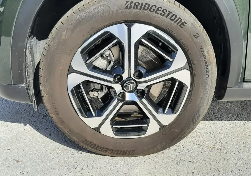 Gros plan sur la roue avant gauche d'une Citroën C3 Aircross vert Montana avec jante alliage noire et argent.
