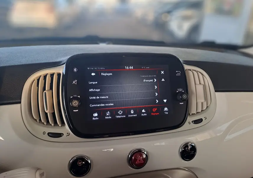 Écran tactile central du tableau de bord blanc de la Fiat 500 2023 affichant le menu réglages en français.