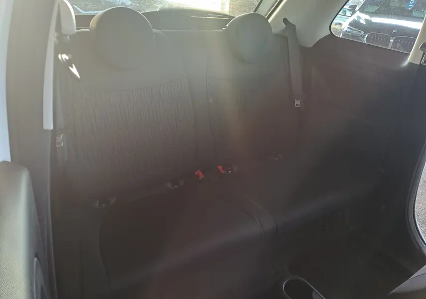 Vue intérieure arrière des sièges noirs de la Fiat 500 2023 avec motif FIAT en relief sur les dossiers.