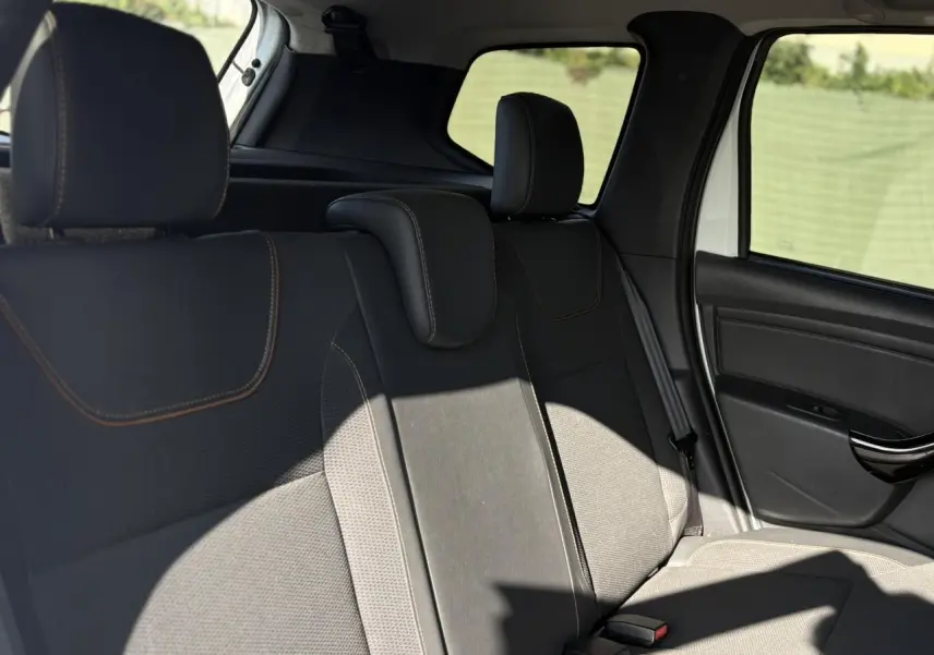 Vue côté droit des sièges arrière en cuir et tissu noir du Dacia Duster blanc Glacier 2017 avec appuie-têtes réglables.