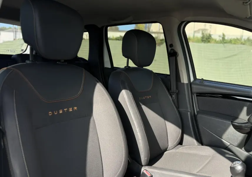 Vue intérieure des sièges avant noirs avec surpiqûres et logo DUSTER du Dacia Duster TCE 125 Explorer 2017.