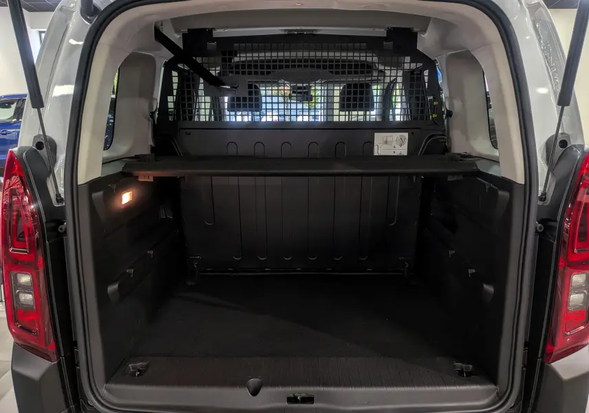 Coffre ouvert d'un Citroën Berlingo Blanc Glacier 2025, vue arrière montrant la cloison de séparation et l'espace de chargement.