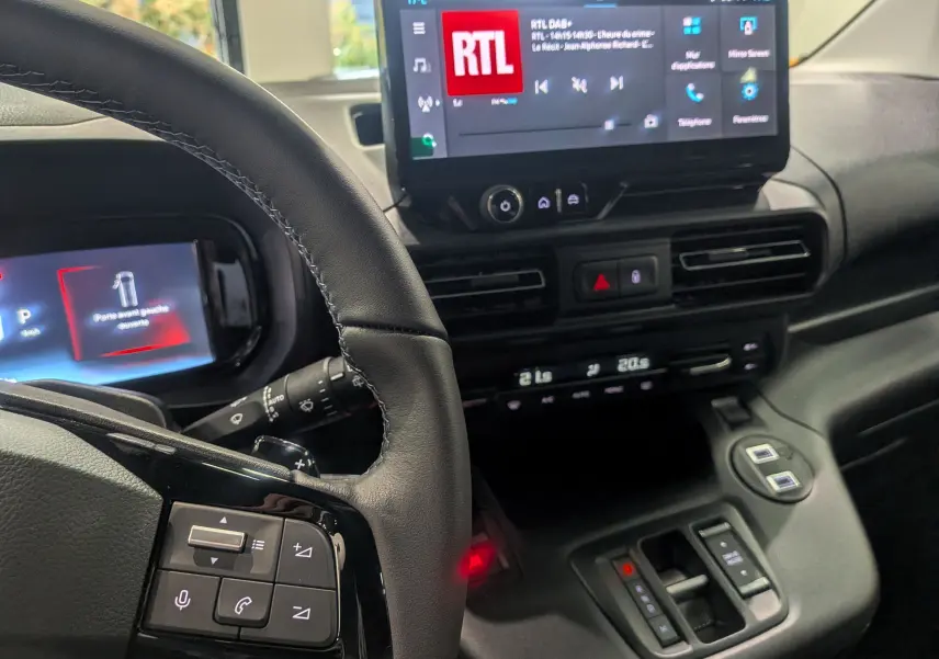 Vue rapprochée de l'intérieur du Citroën Berlingo 2025, tableau de bord et volant avec commandes intégrées.