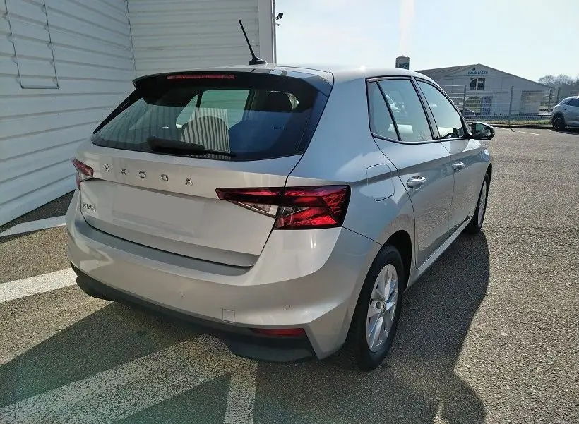 Vue 3/4 arrière droite d'une Skoda Fabia blanche 5 portes de 2023, avec feux arrière LED et antenne de toit.