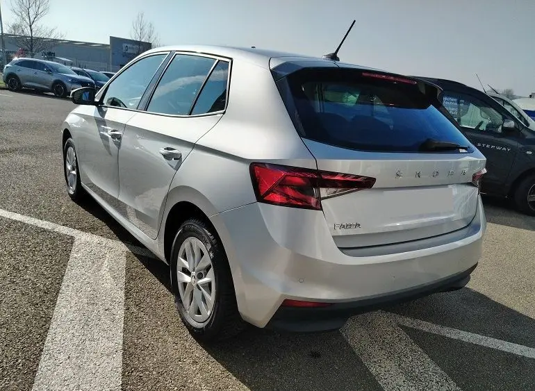 Vue 3/4 arrière droite d'une Skoda Fabia blanche 5 portes de 2023, avec feux arrière LED et vitres teintées.