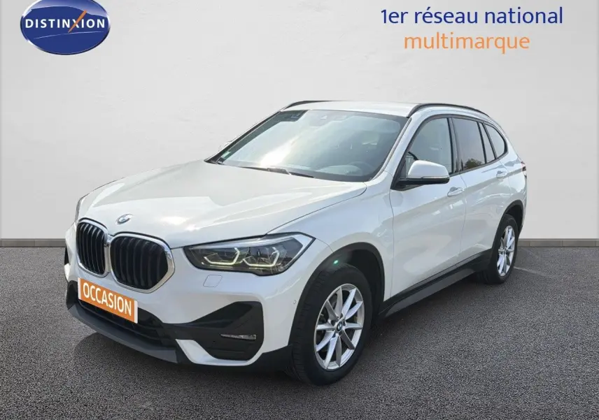 BMW X1 blanc vue 3/4 avant droit, avec calandre noire et jantes alliage 17 pouces visibles.