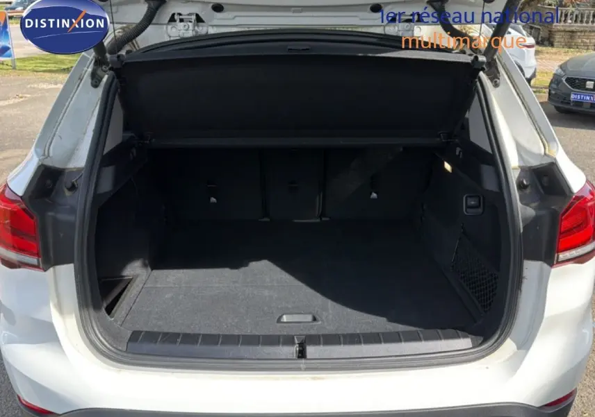 Coffre ouvert vu de l'arrière d'un BMW X1 blanc, montrant un espace de chargement spacieux et propre.