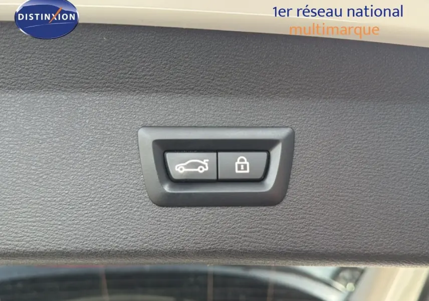 Gros plan sur les boutons d'ouverture de coffre et de verrouillage, intérieur d'un BMW X1 blanc de 2022.