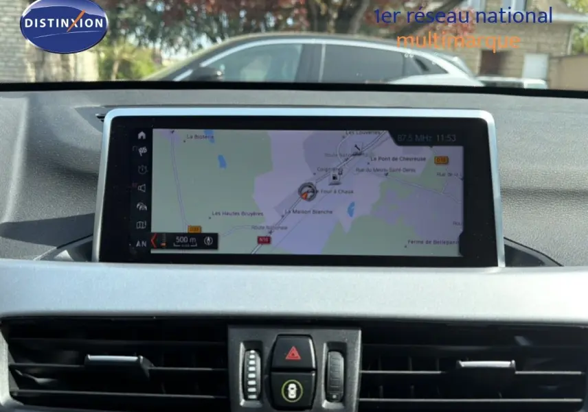 Vue intérieure centrée sur l'écran tactile du système de navigation du BMW X1 blanc, version 2022.