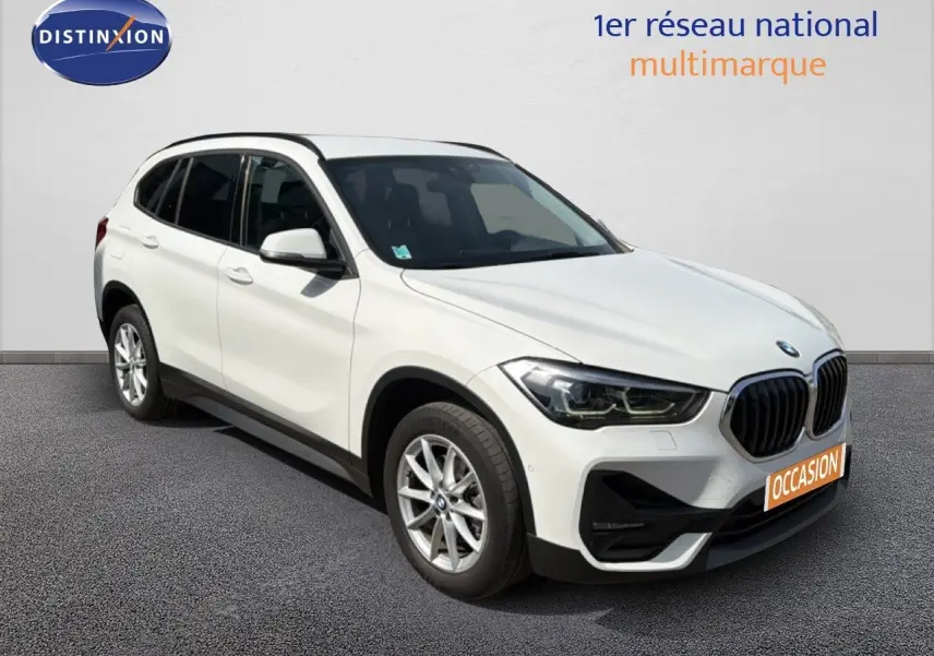 BMW X1 blanc en vue 3/4 avant droit, avec calandre noire et jantes alliage 17 pouces visibles.