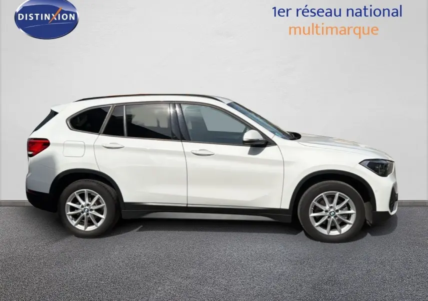 BMW X1 blanc en profil droit, SUV compact avec jantes alliage et vitres teintées, sur fond neutre.