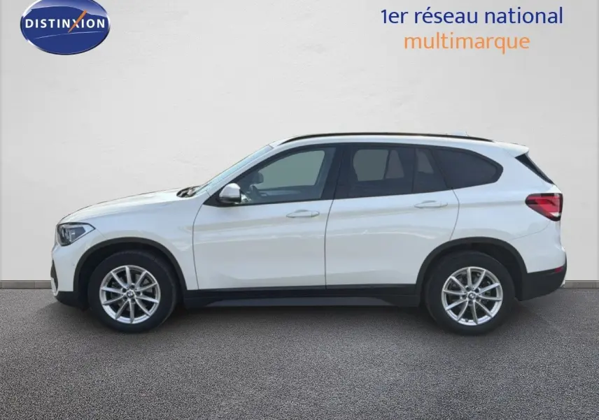 BMW X1 blanc vue de profil côté gauche sur fond neutre, soulignant ses lignes modernes et ses jantes alliage.