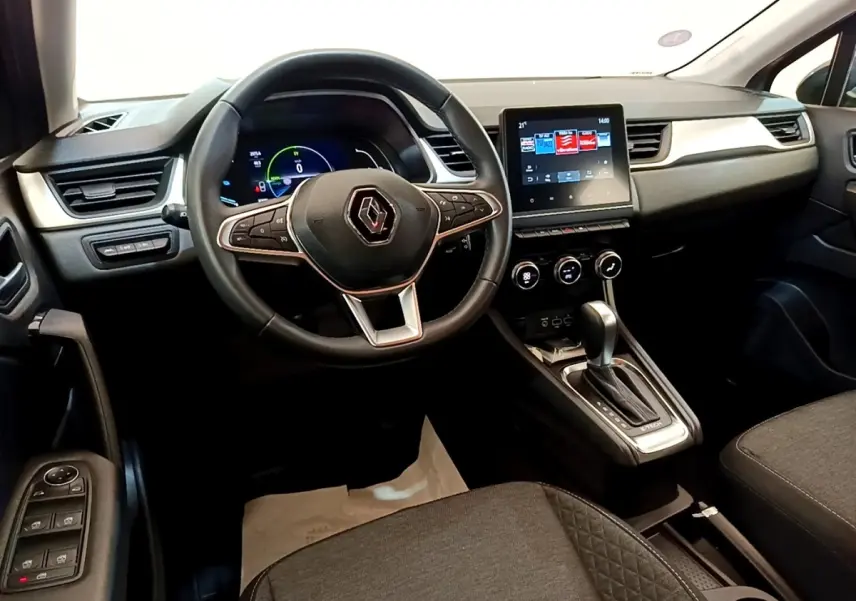 Vue intérieure du poste de conduite du Renault Captur Zen E-Tech hybride 2022, avec volant multifonctions et écran tactile central.