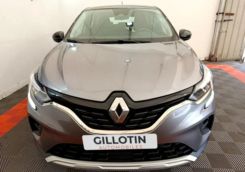 Vue frontale d’un Renault Captur Zen E-Tech hybride gris foncé avec calandre noire et feux LED allumés.