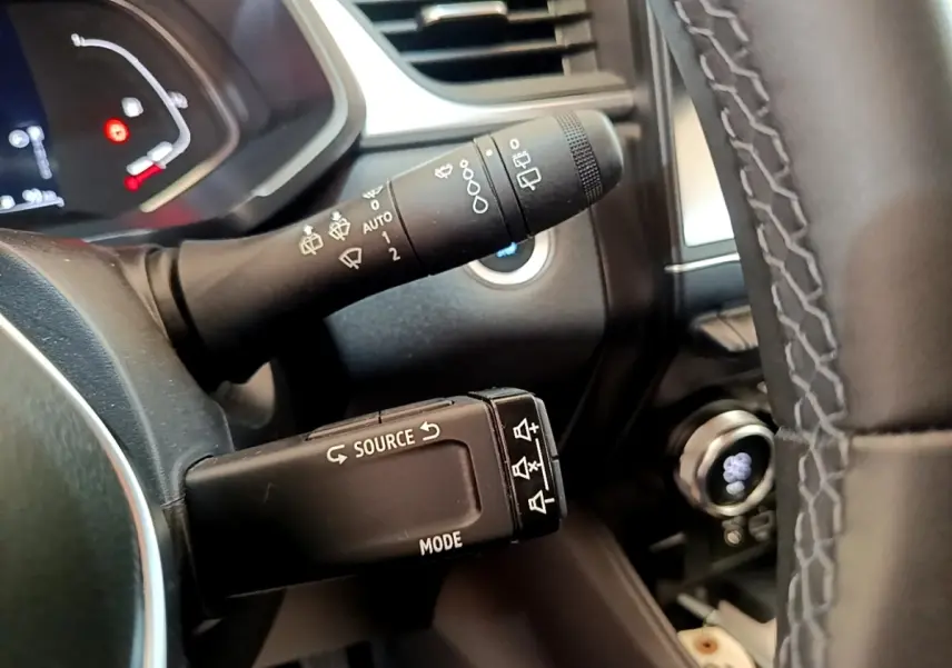 Gros plan sur la commande multifonction et le commodo d’essuie-glace du tableau de bord d’un Renault Captur gris foncé 2022.