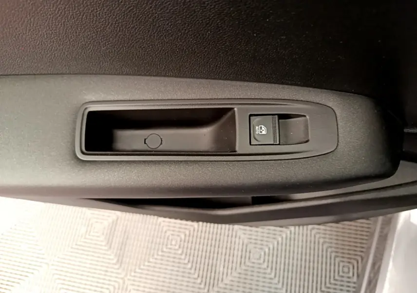 Gros plan sur le bouton de lève-vitre électrique côté conducteur du Renault Captur Zen E-Tech hybride gris foncé.