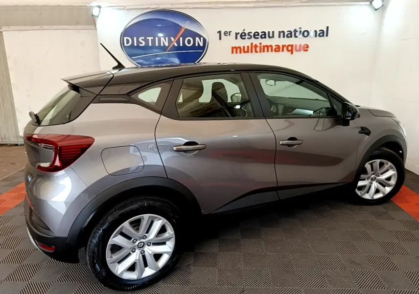 Renault Captur Zen E-Tech hybride gris foncé vu de profil côté droit dans un showroom intérieur.